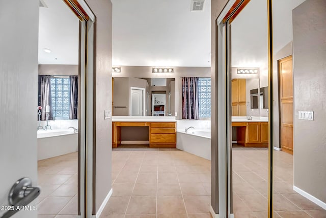 bathroom featuring vanity, a bathtub, and tile patterned floors