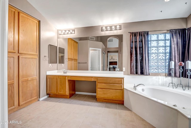 bathroom with a bathing tub, tile patterned flooring, and vanity