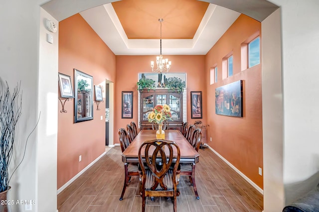 dining room with a notable chandelier and a tray ceiling