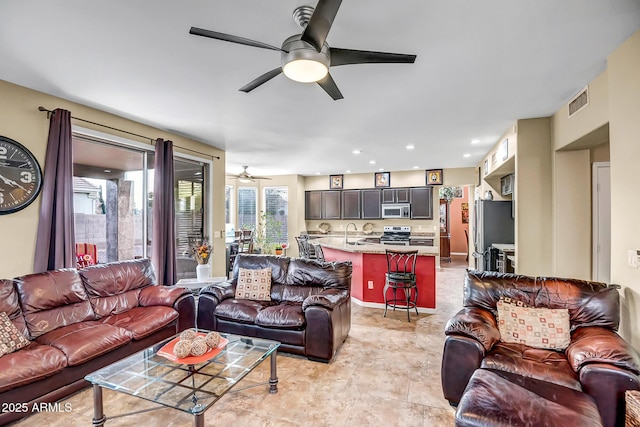 living room featuring ceiling fan and sink