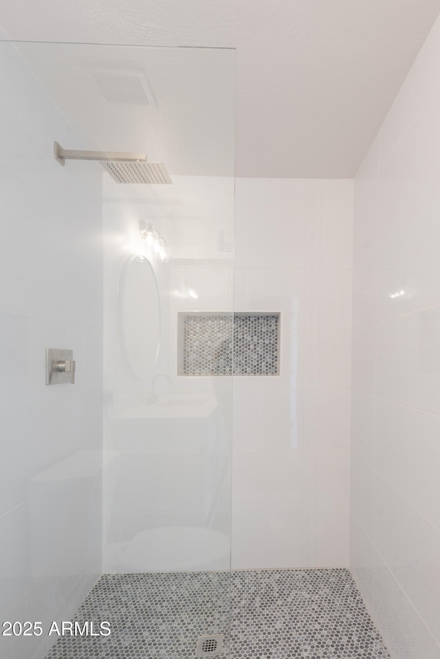 bathroom with a tile shower and sink