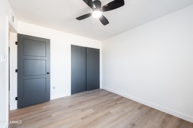 unfurnished bedroom with ceiling fan, a closet, and light hardwood / wood-style flooring