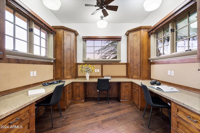 office space featuring ceiling fan, built in desk, and dark hardwood / wood-style floors