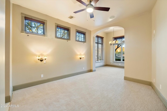 carpeted spare room featuring ceiling fan and a healthy amount of sunlight