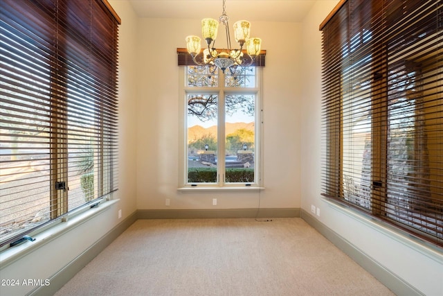 dining room with light colored carpet and an inviting chandelier