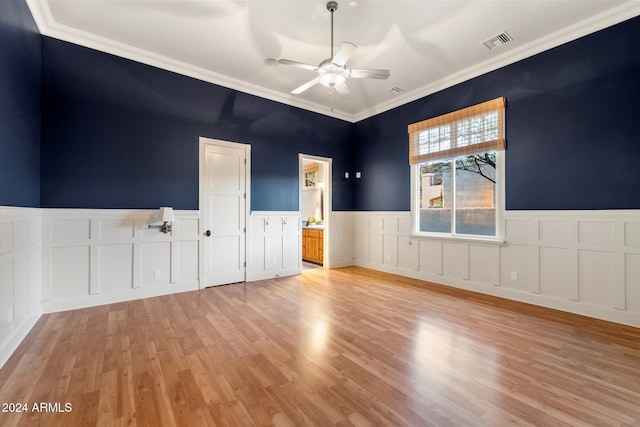 empty room featuring ceiling fan, light hardwood / wood-style floors, and ornamental molding