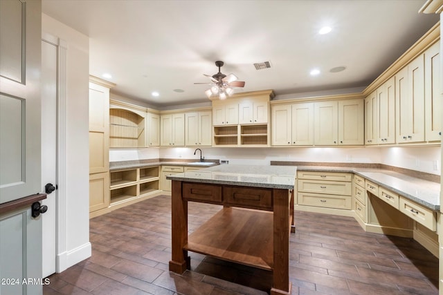 kitchen with light stone countertops, cream cabinets, and dark hardwood / wood-style flooring