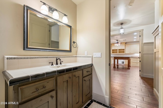 bathroom with hardwood / wood-style flooring, ceiling fan, and vanity