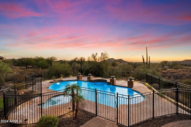 pool at dusk with a patio area