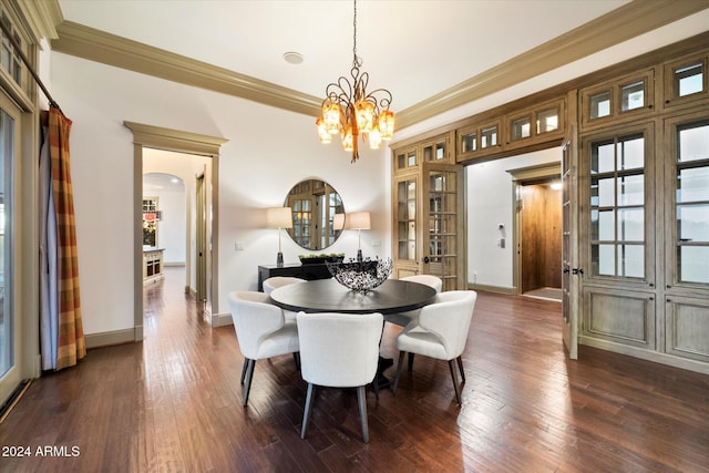 dining area featuring dark hardwood / wood-style floors, an inviting chandelier, and crown molding