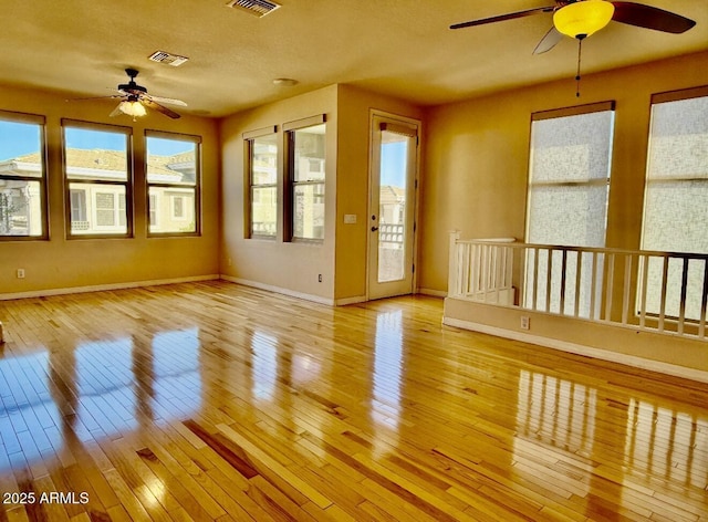 unfurnished sunroom with ceiling fan