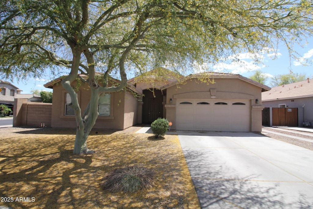 single story home featuring a garage, fence, stucco siding, and concrete driveway
