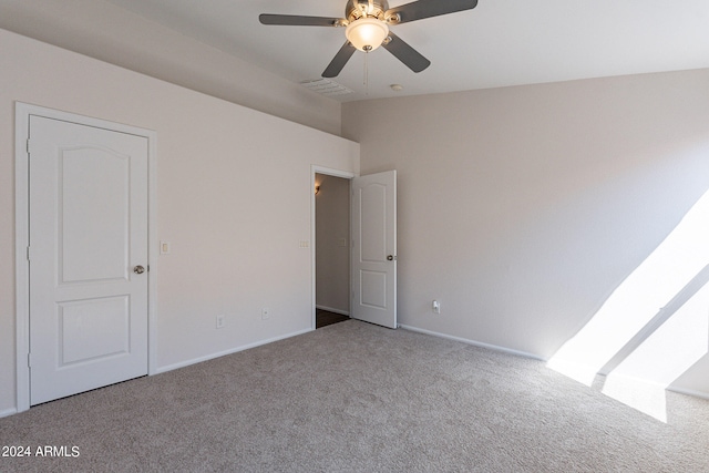 empty room with ceiling fan and carpet floors