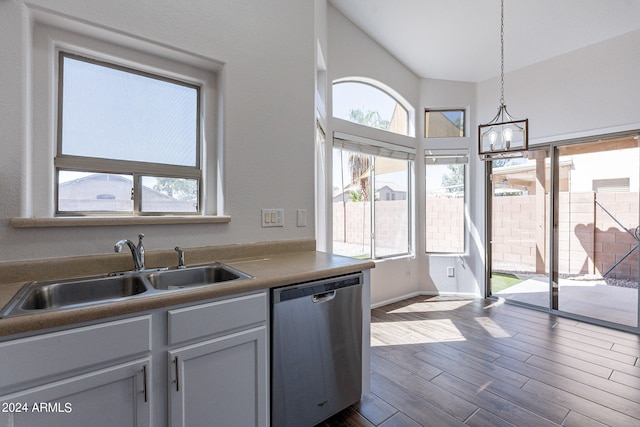 kitchen featuring hanging light fixtures, sink, dark wood-type flooring, dishwasher, and an inviting chandelier