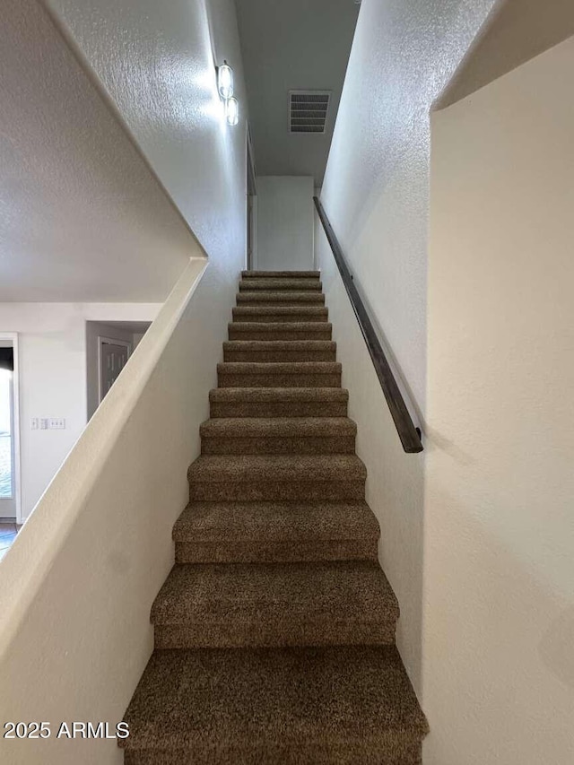 stairway with a textured ceiling