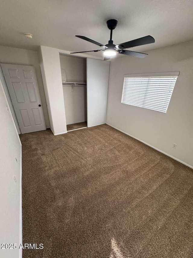 unfurnished bedroom featuring ceiling fan, a closet, and carpet floors