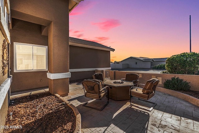 patio terrace at dusk featuring an outdoor fire pit