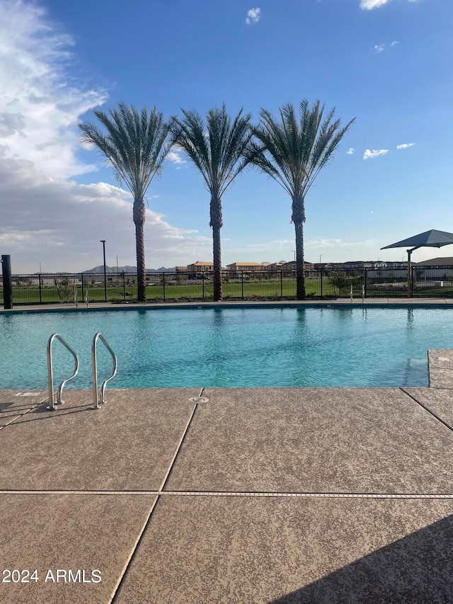 pool with a water view and fence