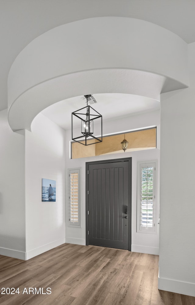 foyer with hardwood / wood-style floors and a chandelier