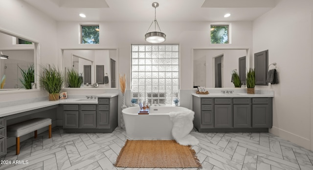 bathroom featuring two vanities, a soaking tub, a sink, and recessed lighting