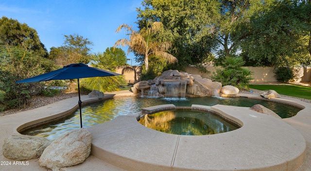 view of pool with a fenced backyard and a pool with connected hot tub