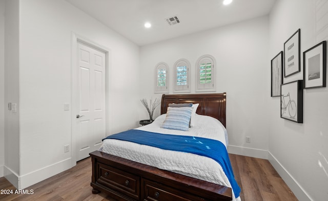 bedroom featuring baseboards, visible vents, wood finished floors, and recessed lighting