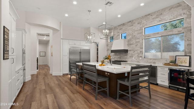 dining area with arched walkways, wine cooler, recessed lighting, wood finished floors, and visible vents