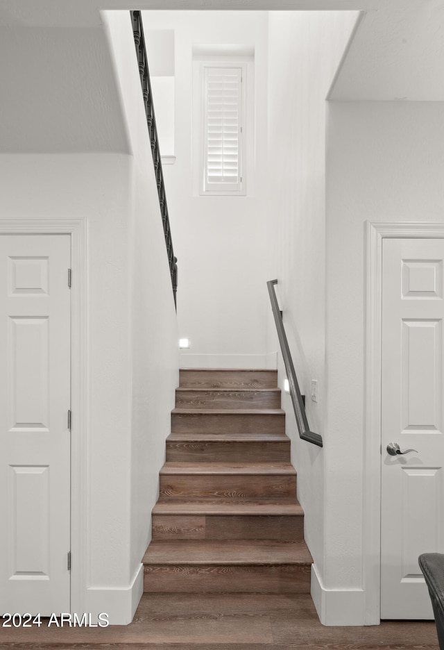 stairway with baseboards and wood finished floors