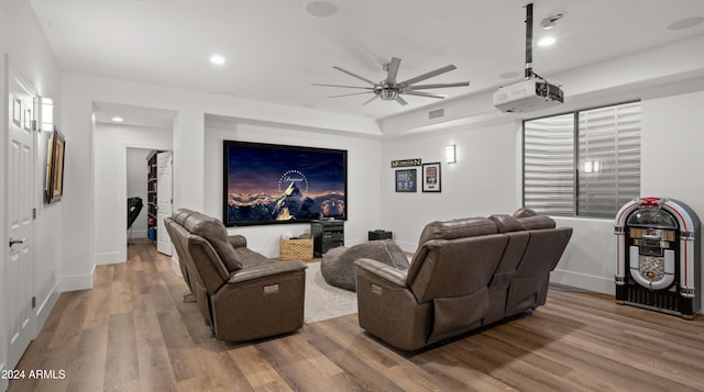 home theater featuring visible vents, ceiling fan, baseboards, and wood finished floors