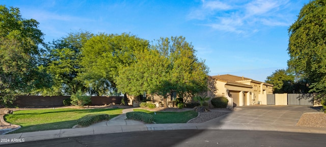 view of front facade featuring a garage, a front yard, driveway, and fence