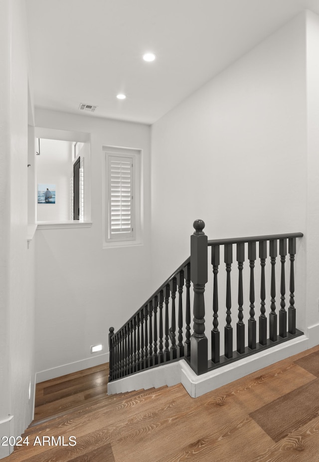 stairs featuring baseboards, visible vents, wood finished floors, and recessed lighting