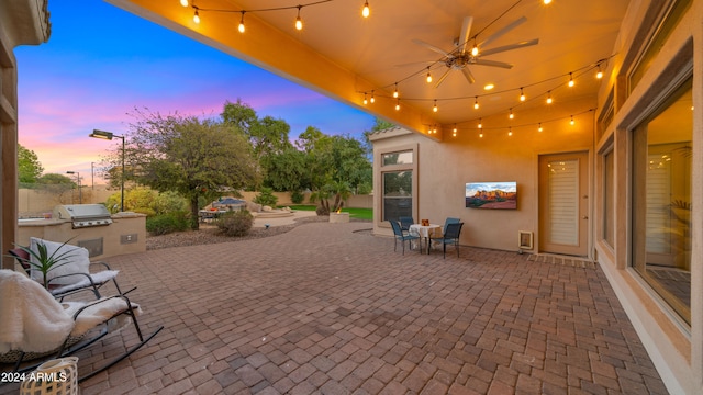 view of patio with exterior kitchen, a grill, and a ceiling fan