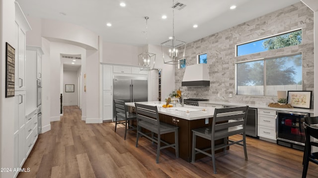 6429 S Honor Ct, Gilbert, AZ 85298 - kitchen with beverage cooler, light countertops, built in refrigerator, a center island with sink, and white cabinets