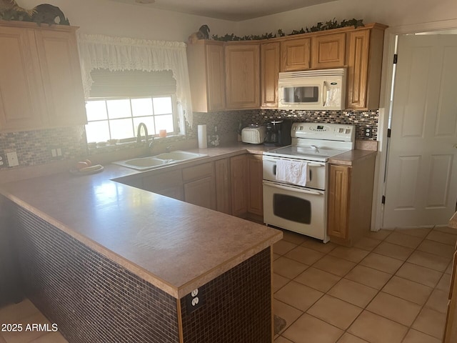 kitchen with sink, white appliances, light tile patterned floors, tasteful backsplash, and kitchen peninsula