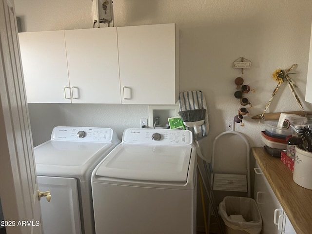 laundry room featuring cabinets and washer and dryer