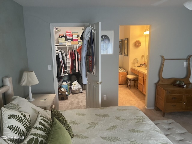 carpeted bedroom featuring ensuite bathroom, a walk in closet, and a closet