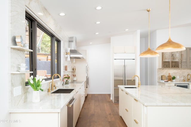 kitchen featuring a sink, wood finished floors, wall chimney range hood, and open shelves