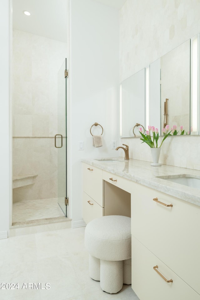 bathroom with double vanity, a stall shower, tile patterned floors, and a sink