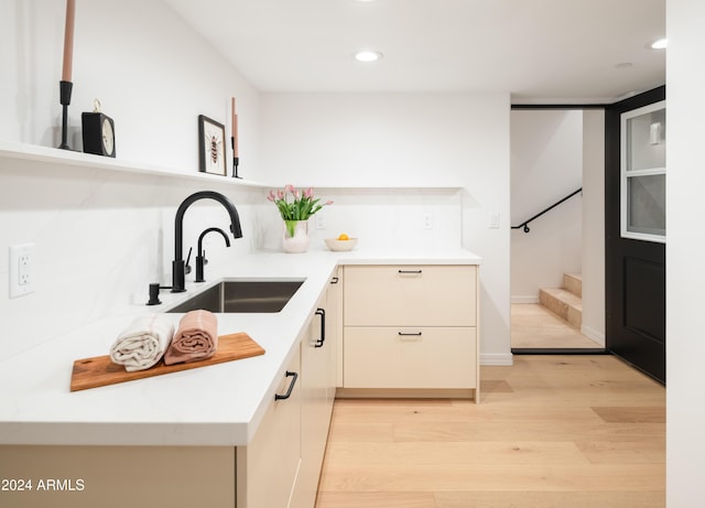 kitchen featuring light wood-type flooring, modern cabinets, a sink, recessed lighting, and light countertops