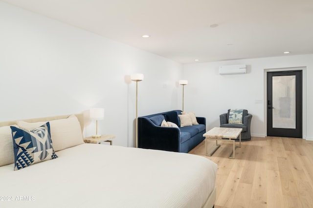 bedroom with recessed lighting, light wood-style flooring, and a wall mounted AC