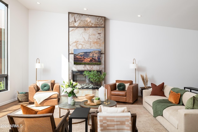 living area featuring recessed lighting, a large fireplace, and wood finished floors