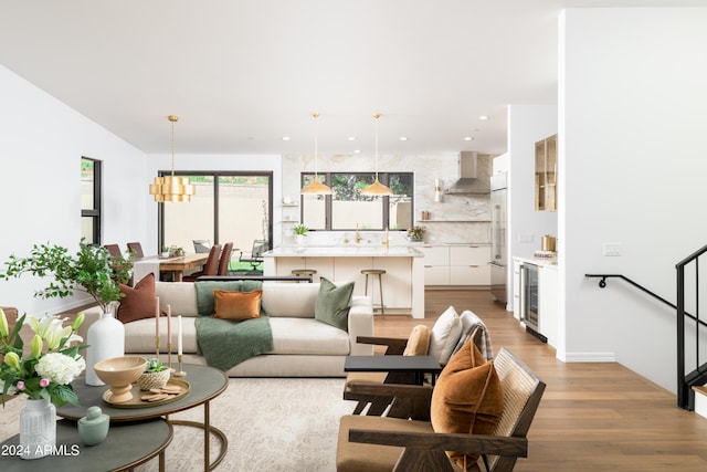 living area featuring recessed lighting, wine cooler, light wood-style flooring, and stairs