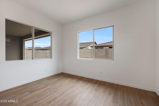 unfurnished room with light wood-type flooring and a wealth of natural light