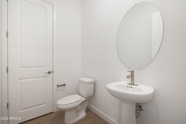 bathroom with wood-type flooring and toilet