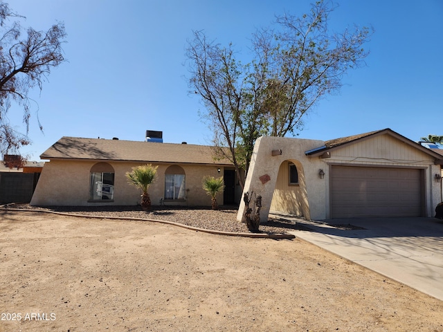 view of front of property with driveway, fence, an attached garage, and stucco siding