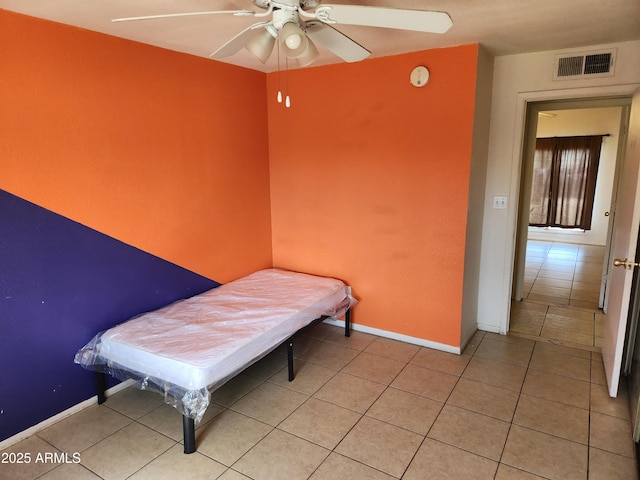 bedroom with light tile patterned floors, visible vents, and baseboards