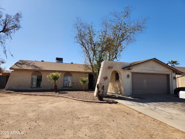 view of front of property featuring a garage, concrete driveway, and stucco siding