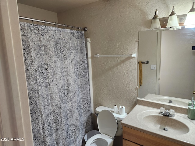 full bathroom with toilet, a textured wall, a shower with shower curtain, and vanity