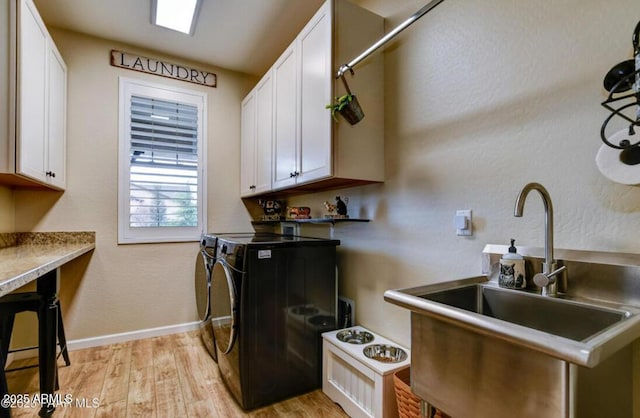 707 Lunar View Way, Chino Valley, AZ 86323 - kitchen featuring washing machine and clothes dryer, light wood-style floors, a sink, white cabinetry, and baseboards