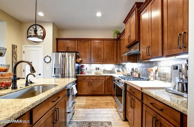707 Lunar View Way, Chino Valley, AZ 86323 - kitchen featuring stainless steel appliances, under cabinet range hood, a sink, light wood-style floors, and light stone countertops